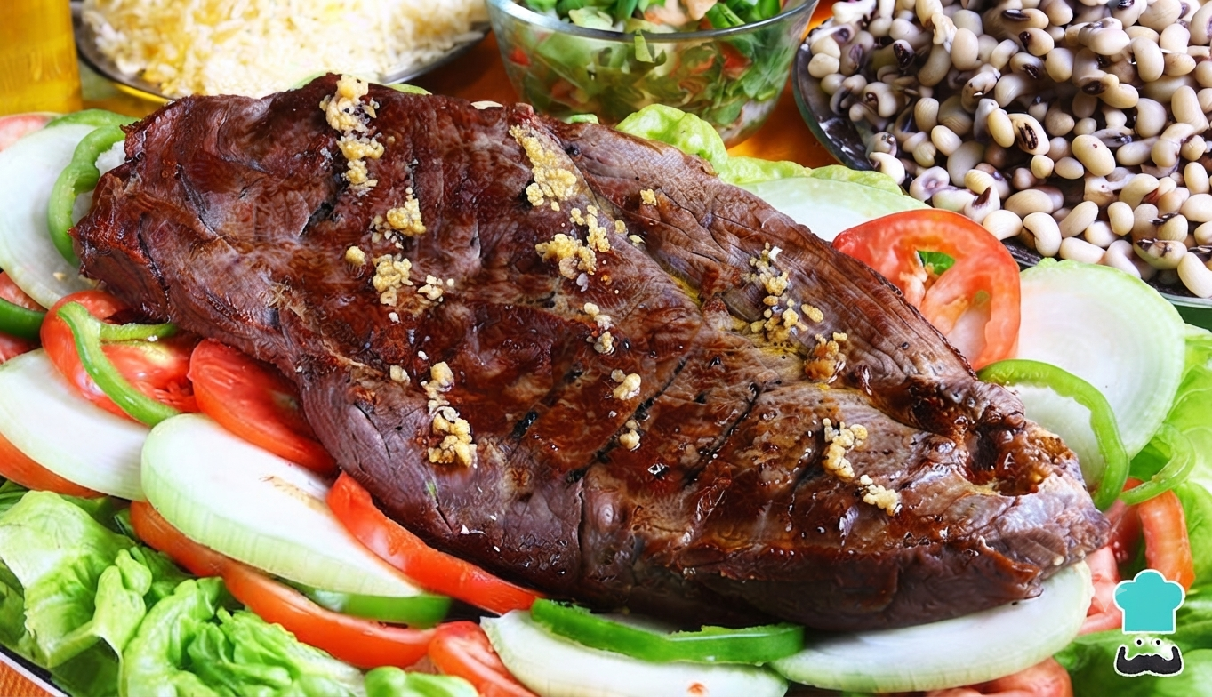 Carne de sol acebolada sobre cama de alface, tomate, cebola e pimentão, com feijão verde ao lado